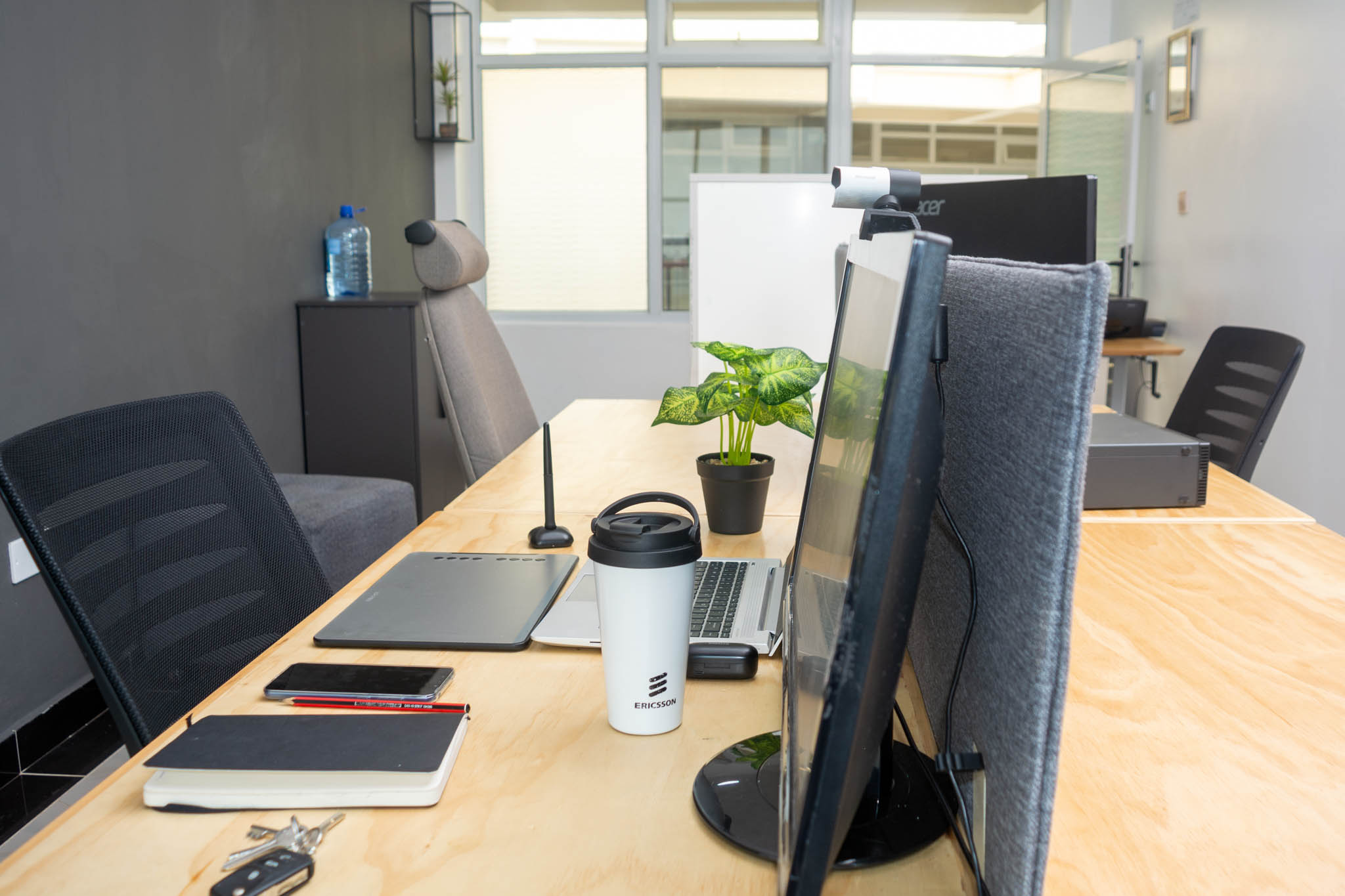 Desk detail with laptop, coffee cup and potted plant at Starshot Workspaces