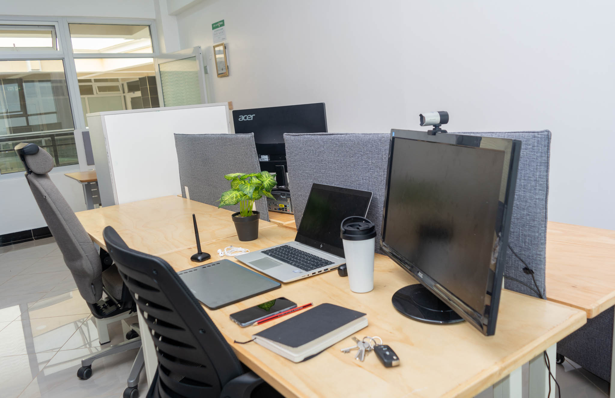Open coworking area with plywood desks, laptops and monitors at Starshot Workspaces
